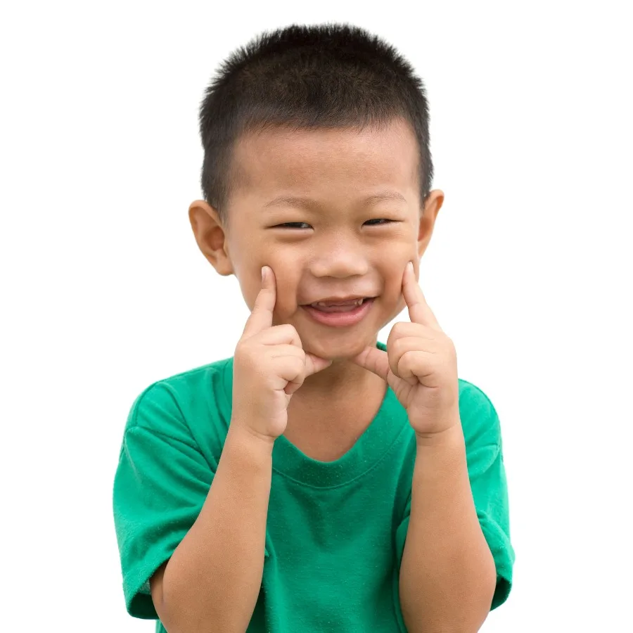 Little boy pointing to his face and smiling