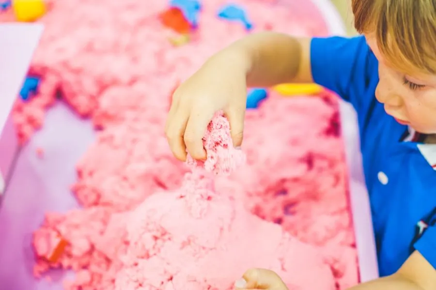 Child playing with sand and shaving cream