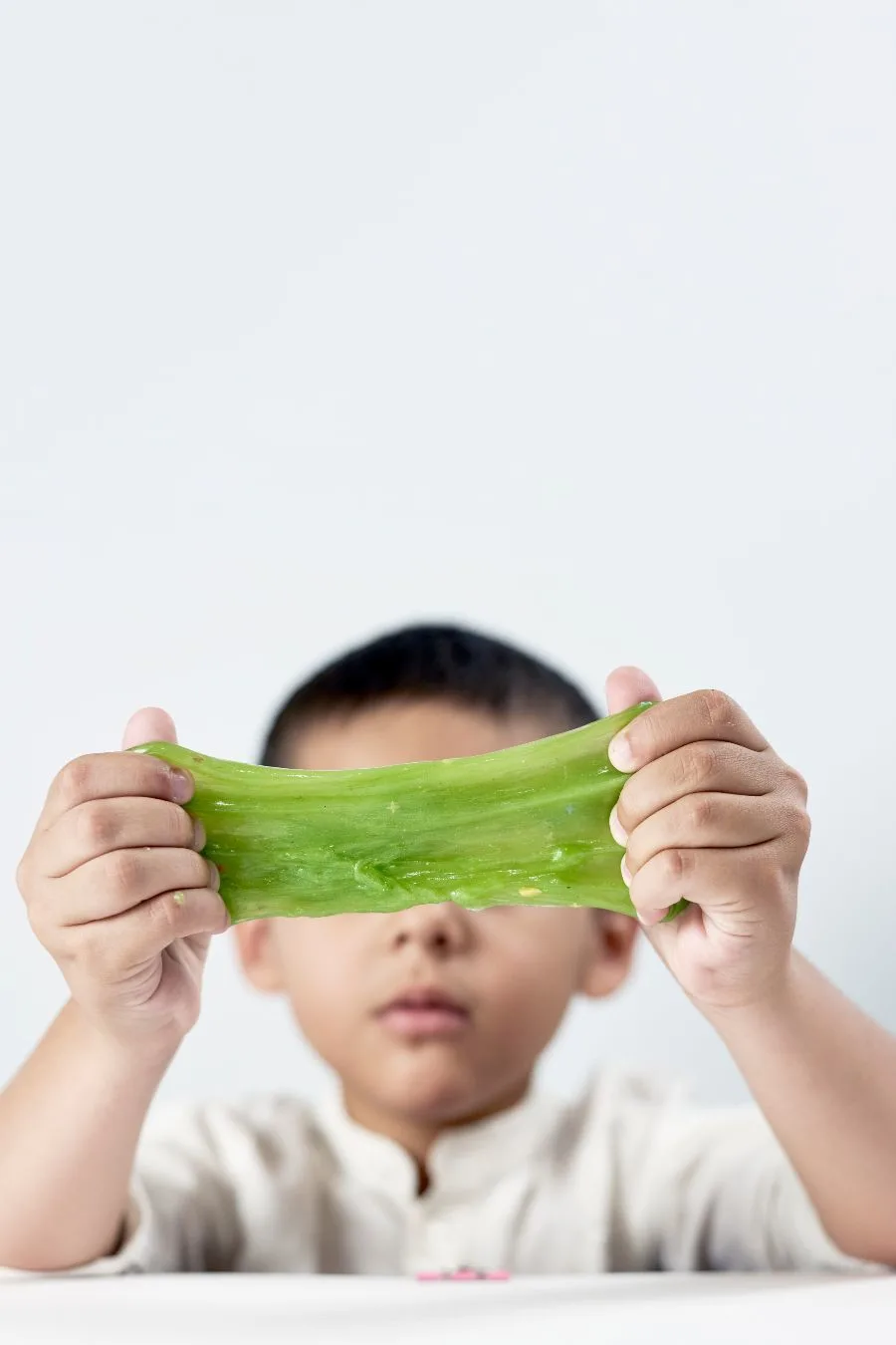 Child playing with green slime