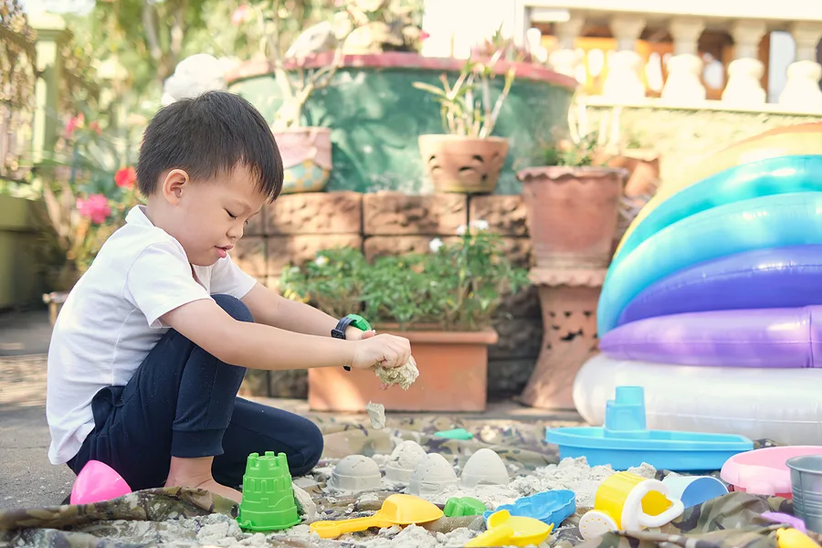 Toddler playing in the sand box outside