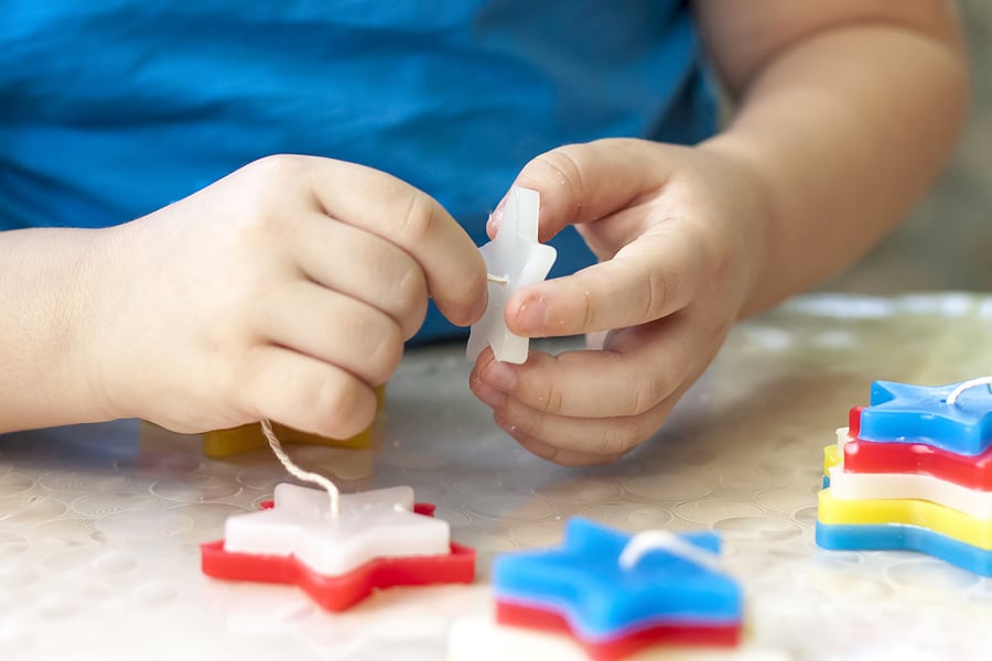 Child threading star shapes onto a string.