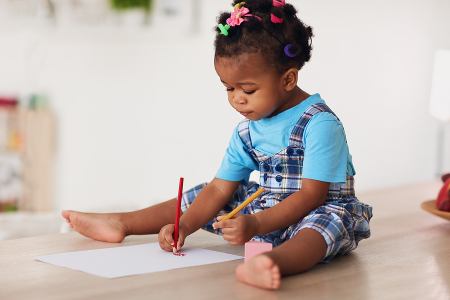 little girl coloring with pencils