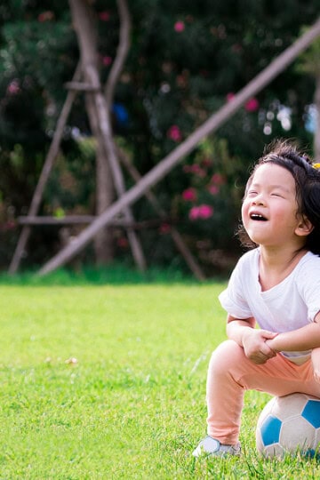 toddler sitting on a soccer ball