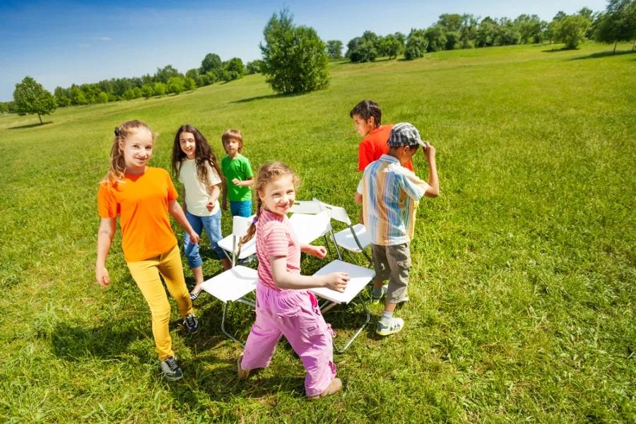 Older children playing a game of musical chairs in the park