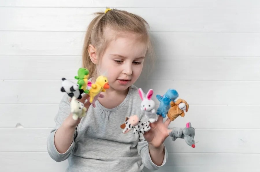 Little girl playing with finger puppets
