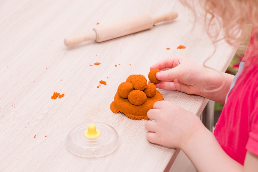 Girl making a turtle with sand and water at a table