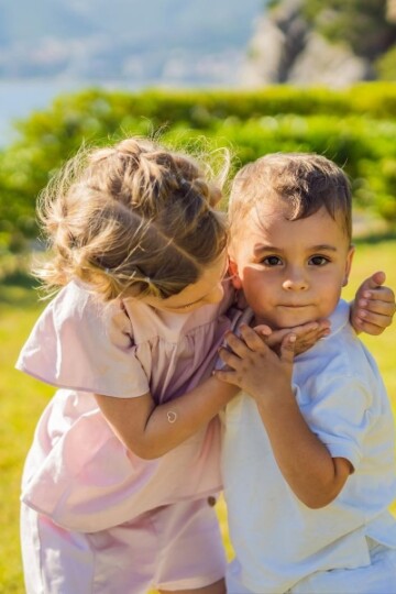 Young girl giving a little boy a hug