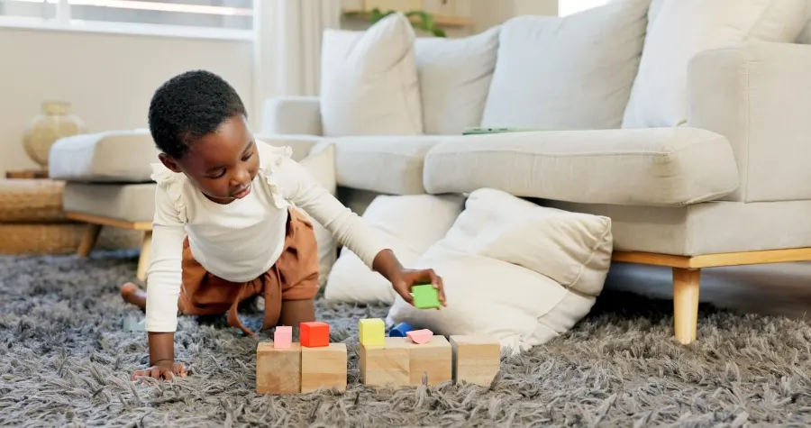 Little girl playing with blocks on her own