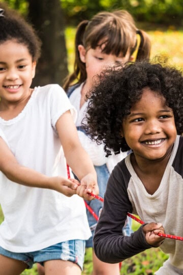 Children in a park playing tug-of-war