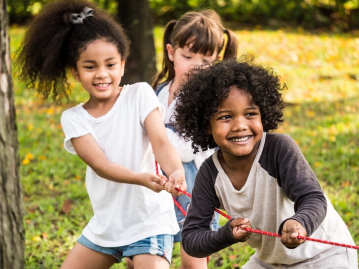 Children in a park playing tug-of-war