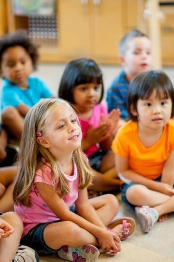 Children in preschool sitting and listening to the teacher