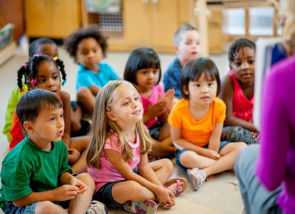 Children in preschool sitting and listening to the teacher