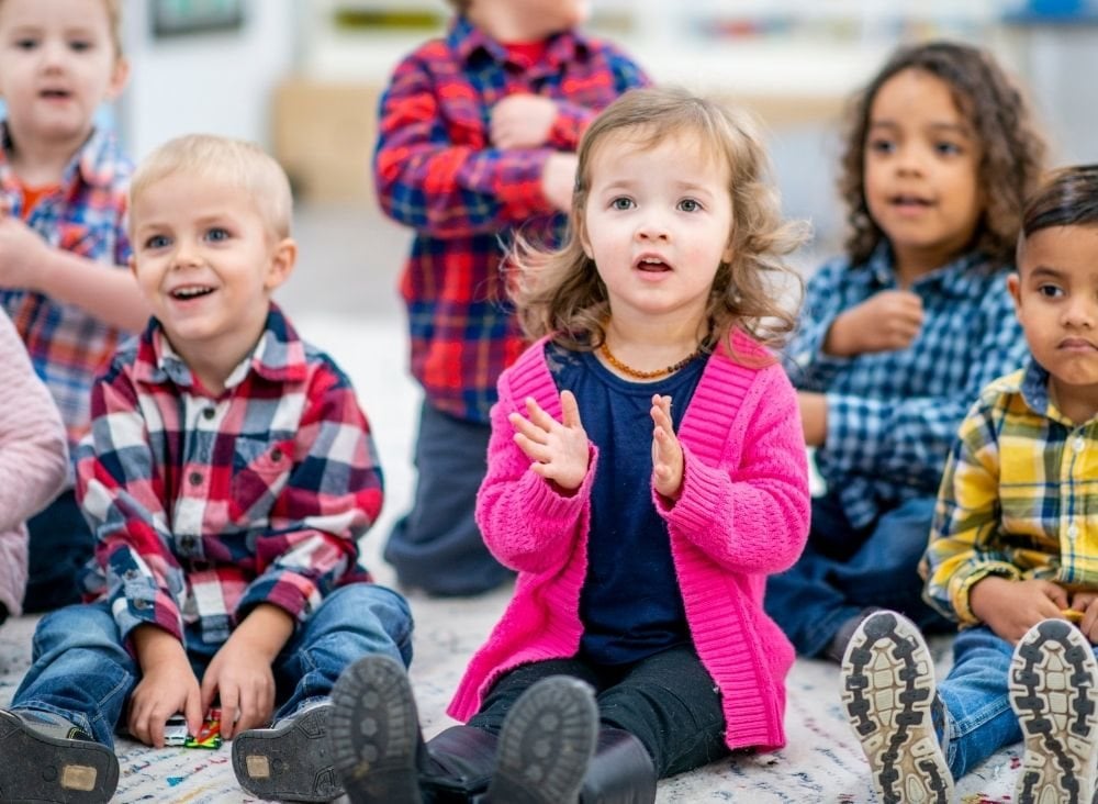 Preschool children sitting on the floor during circle time.