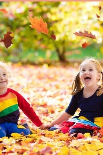 Children playing in colourful autumn leaves